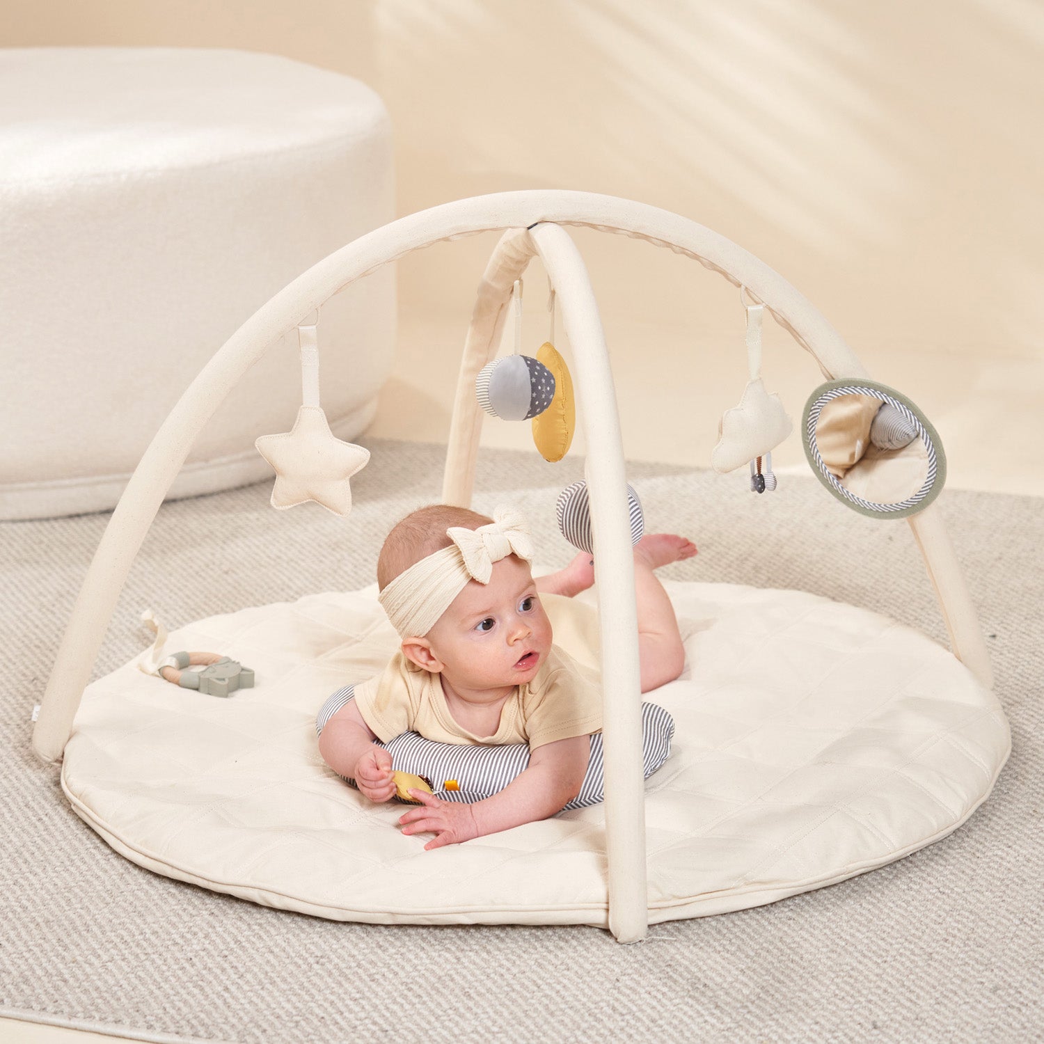 A baby is playing with the MiniDream baby play mat.