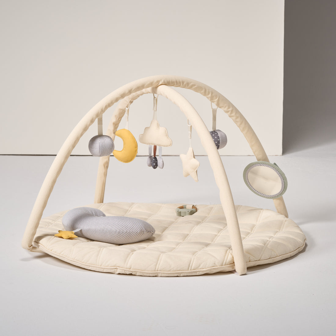 Baby play gym with hanging toys on a light gray background