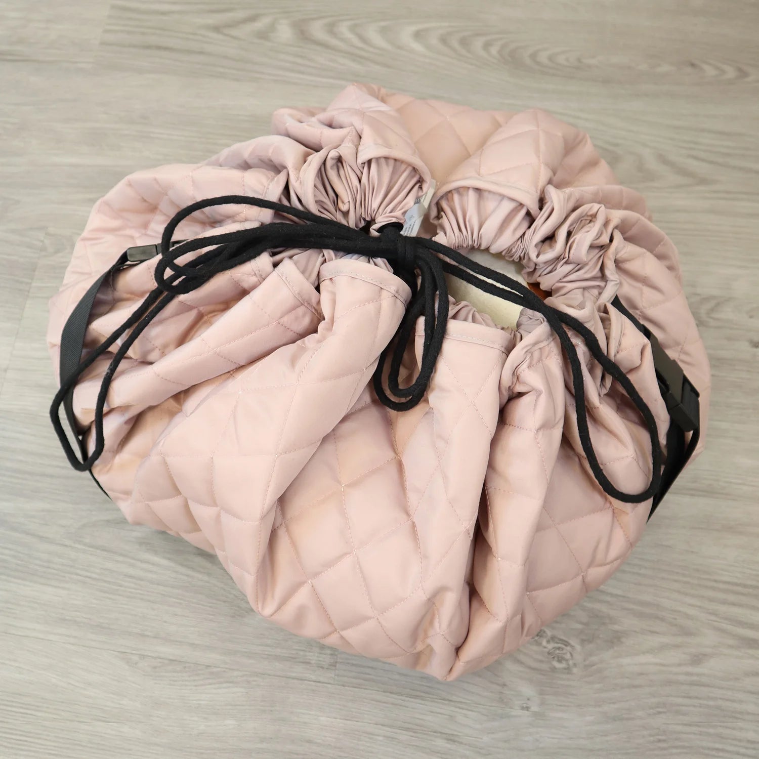 MiniDream 2-in-1 pink toy storage bag fully cinched closed with black drawstrings.