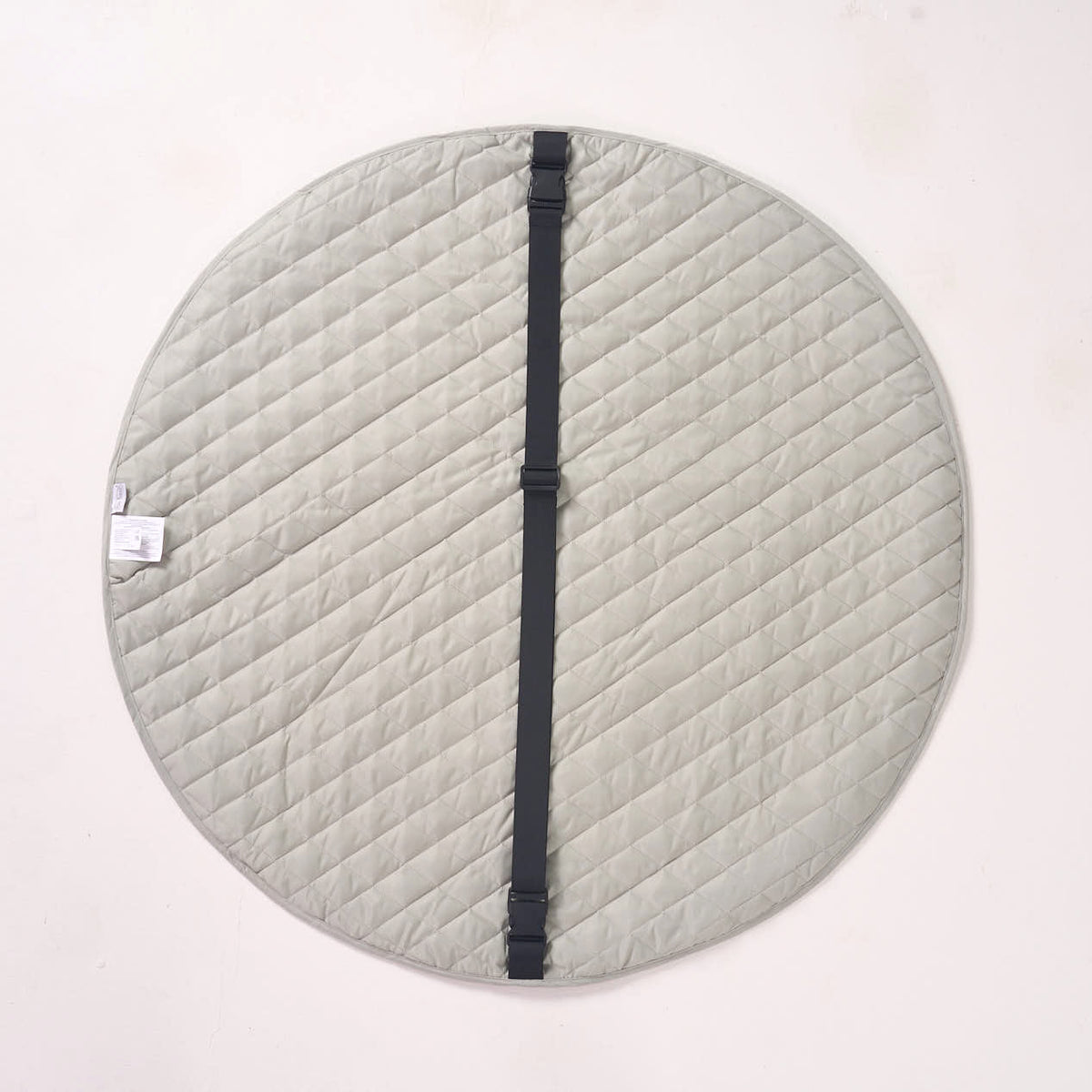 Solid sage green reverse side of the playmat laid flat, featuring a thick black fabric strap running across the center.