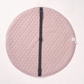 Solid pink reverse side of the MiniDream playmat laid flat, showing an integrated black carrying strap across the center.