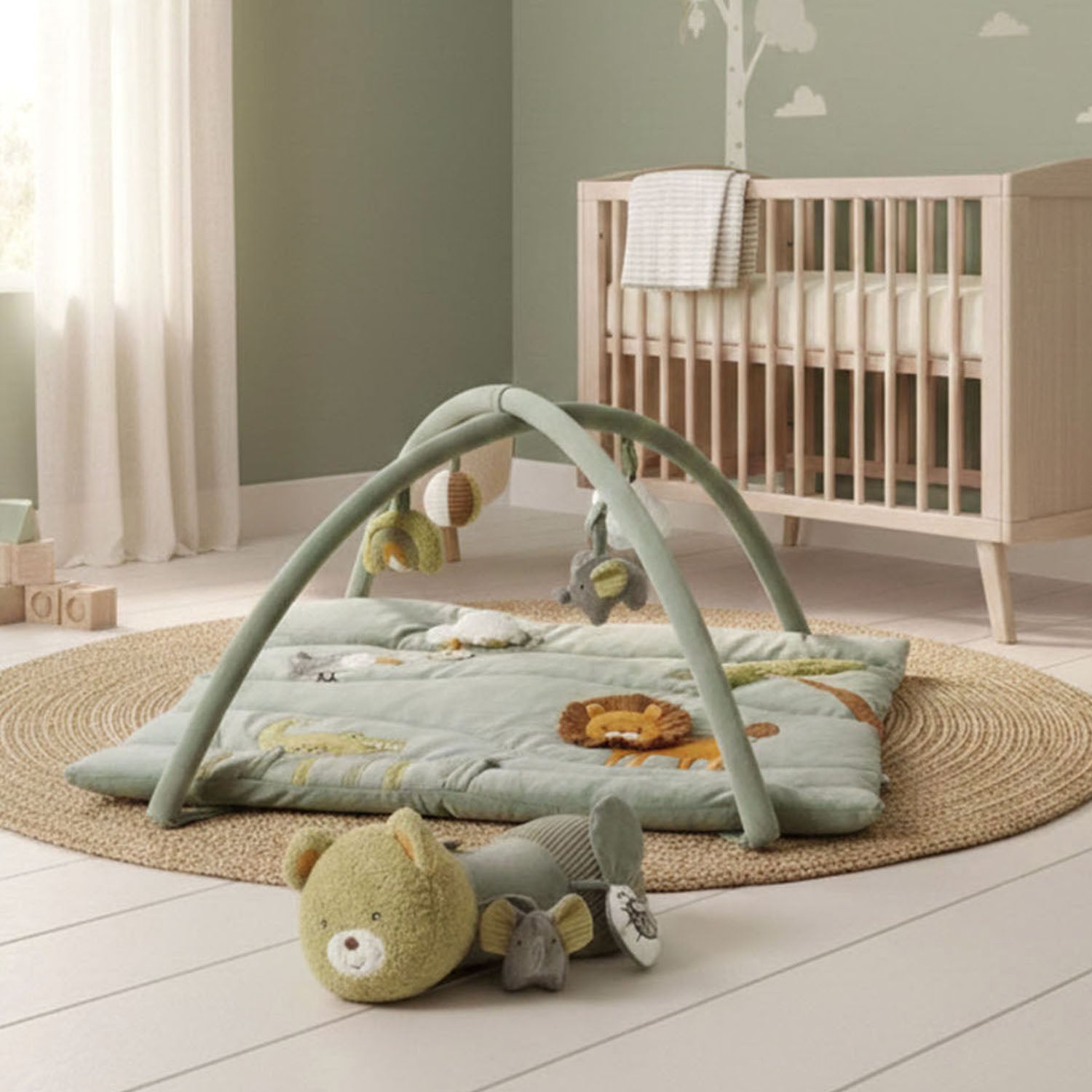 MiniDream activity gym with tummy time roller in a nursery.