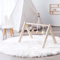 Wooden play gym with toys for babies.
