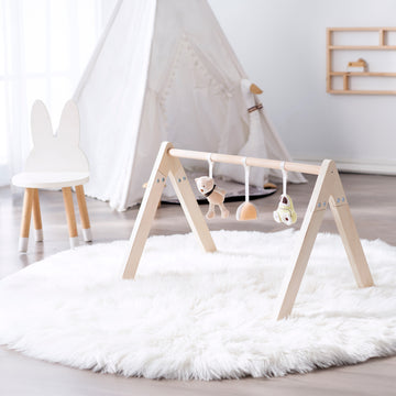 Wooden play gym with toys for babies.