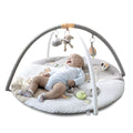 Baby exploring tummy time on cushioned safari mat with colorful animal prints.