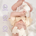 Baby developing fine motor skills by holding the bunny ears of the comforter.